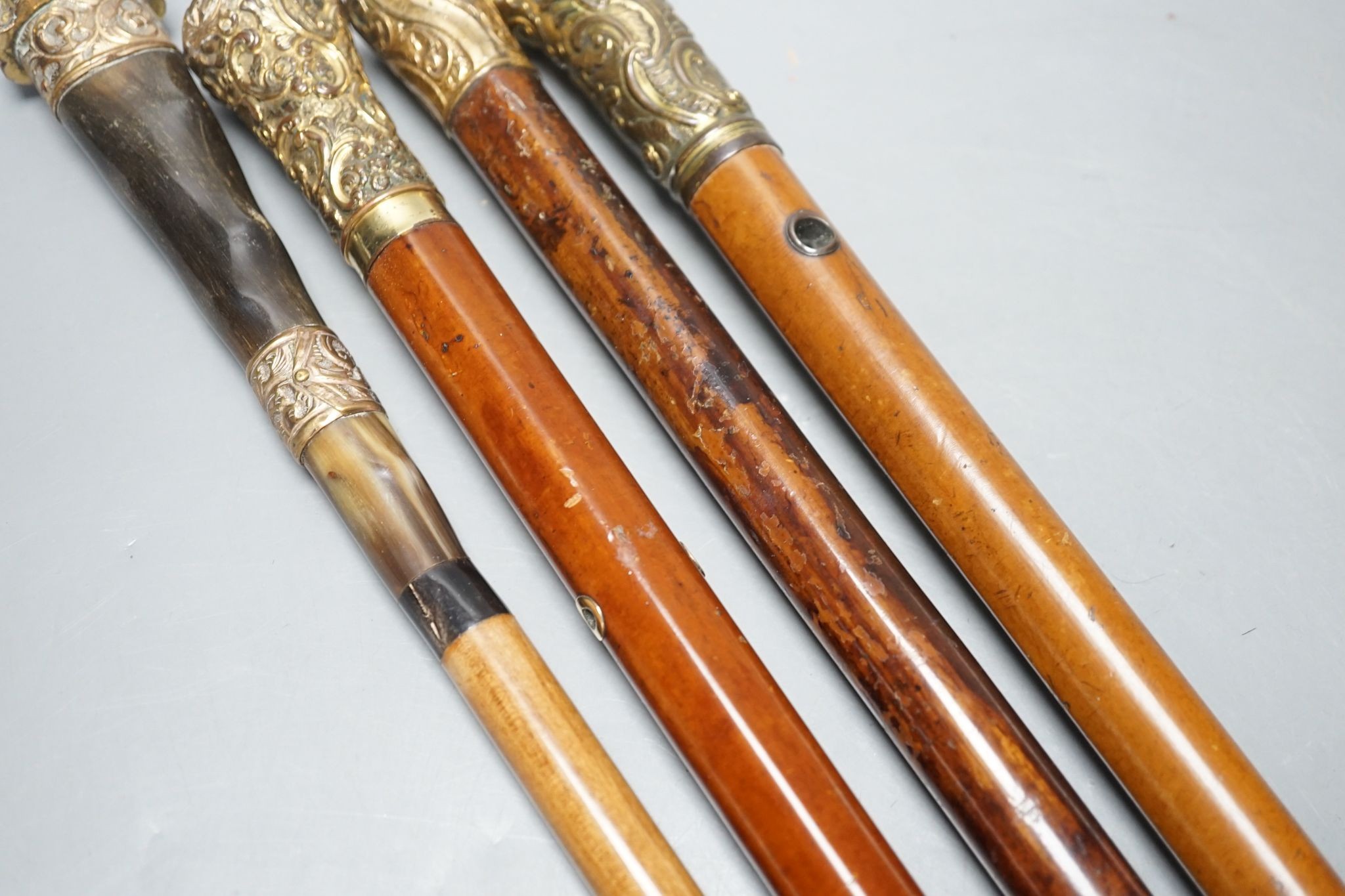 Four Victorian gilt-metal mounted walking canes, longest 97cm